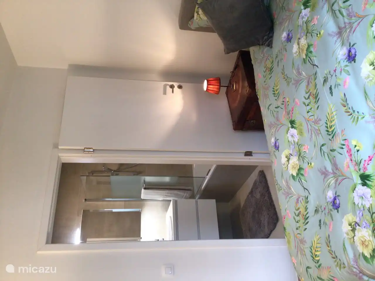 Salle de bain avec lavabo éclairé et barre à bûches avec pomme de douche et poignées