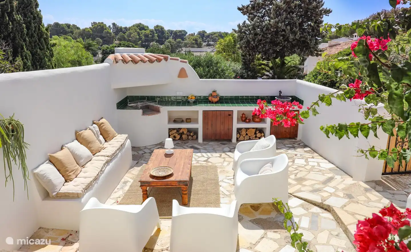 The outdoor kitchen with a nice seating area next to it
