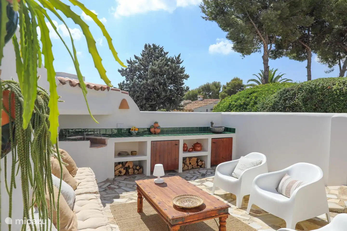 The outdoor kitchen with a nice seating area next to it