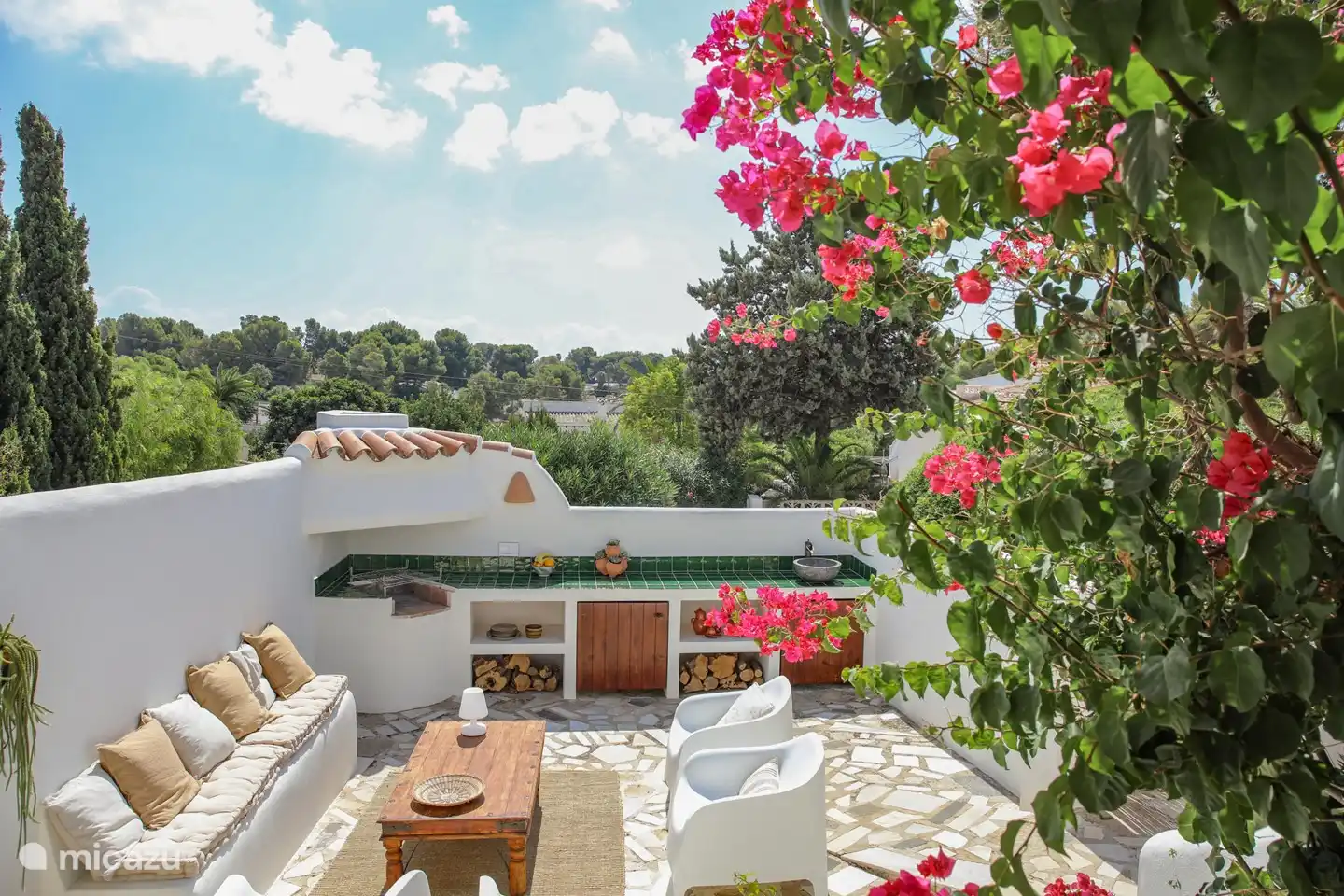 The outdoor kitchen with a nice seating area next to it