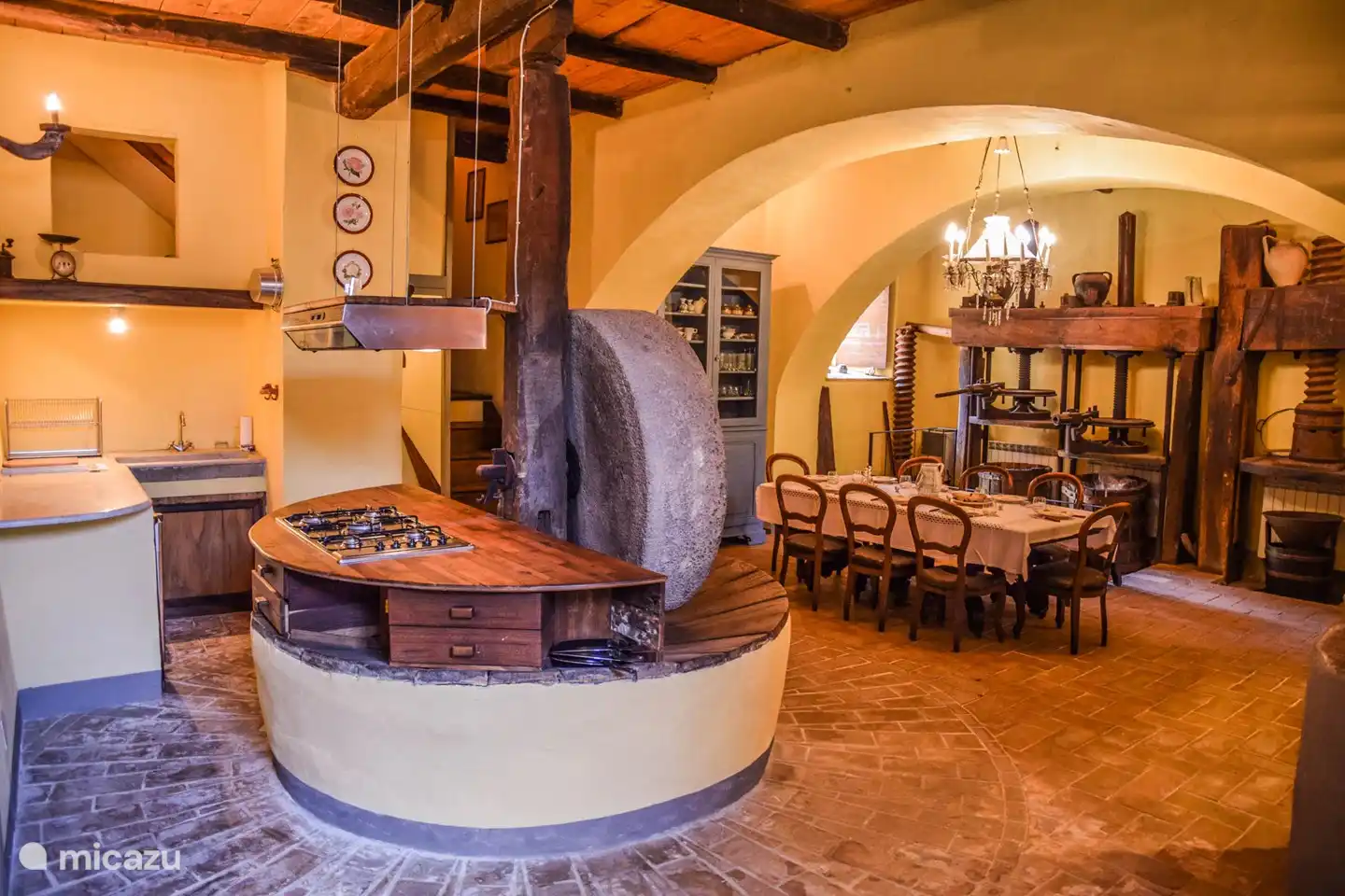 Eine geräumige Küche mit einem antiken Mühlstein für Olivenöl