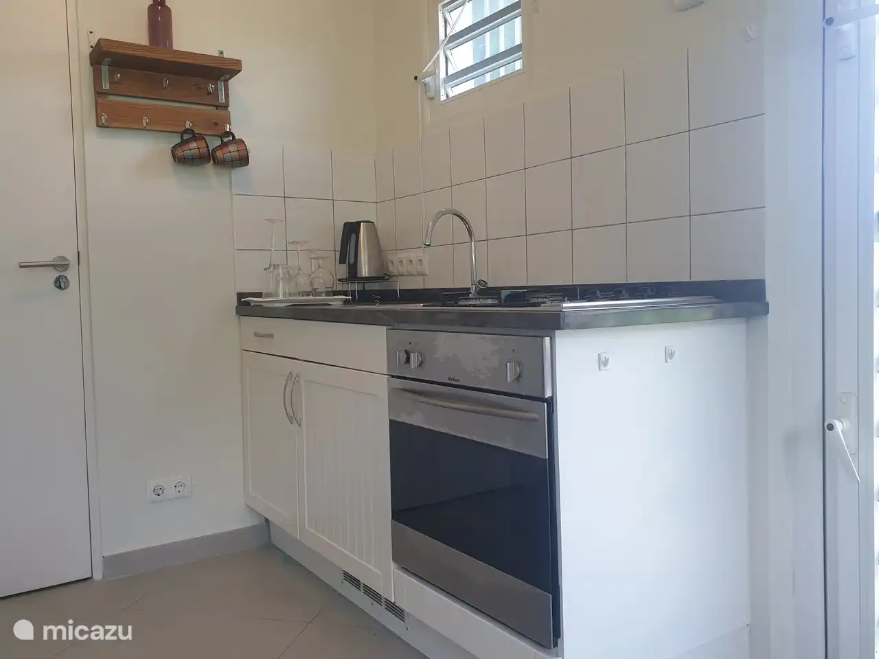 Kitchenette avec cuisinière, four et micro-ondes.