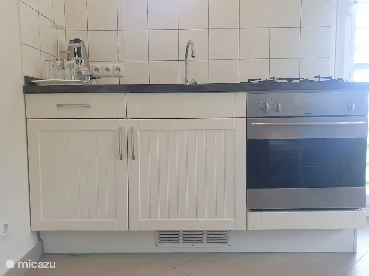 Kitchenette avec cuisinière, four et micro-ondes.