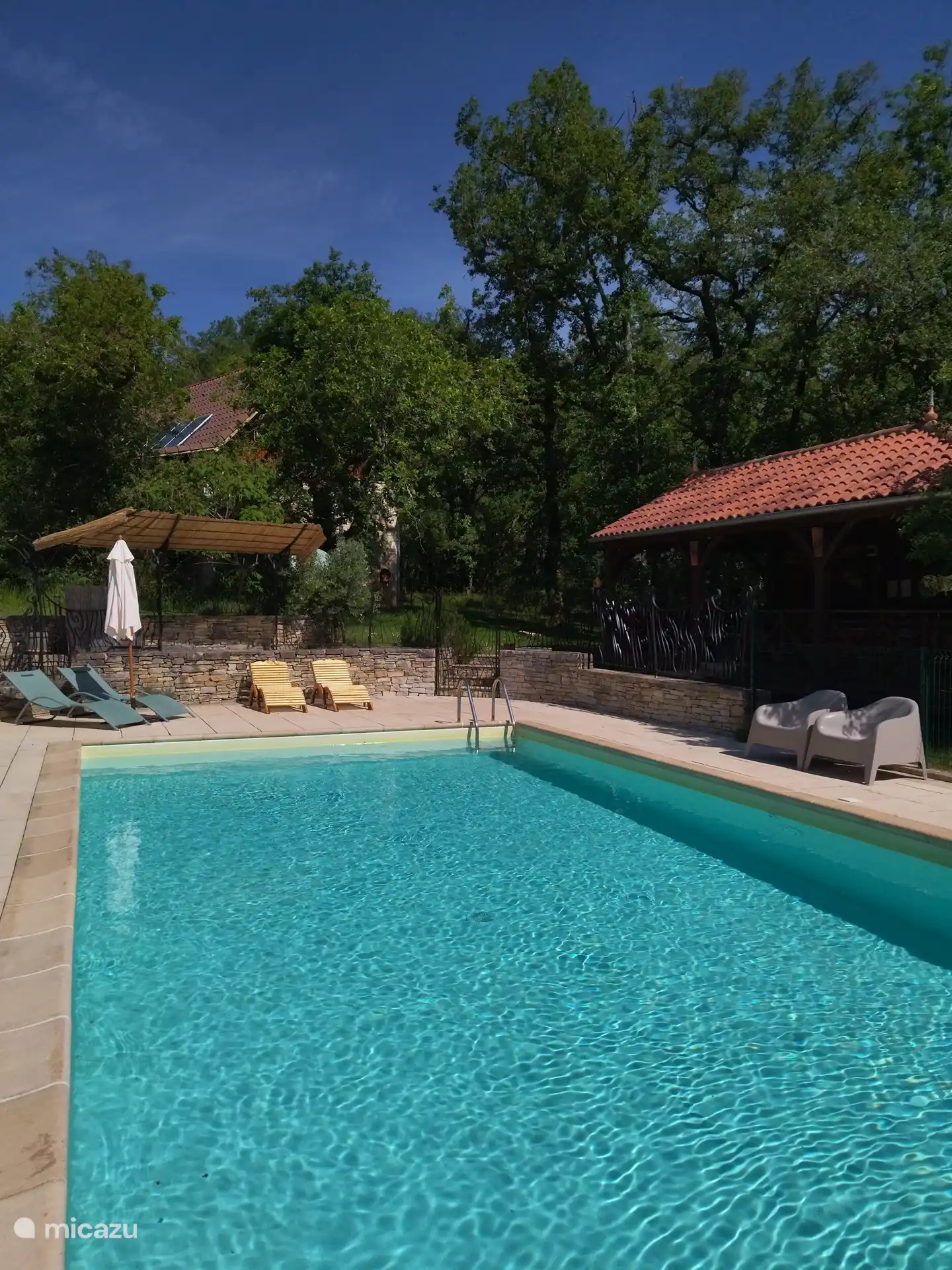 Piscina de agua salada bien vallada con tumbonas