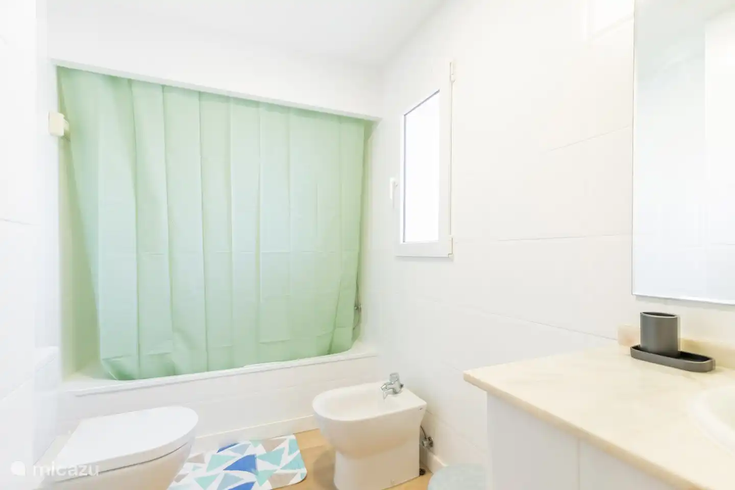 Badkamer met douche/bad, lavabos, toilet en bidet