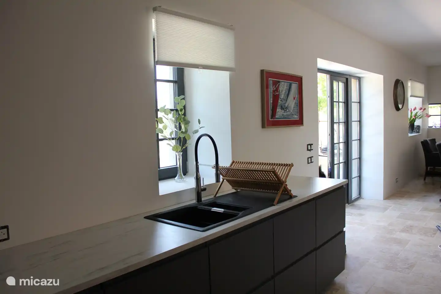 U-förmige Küche mit Kühlschrank, Gefrierschrank, Backofen, Kombi-Mikrowelle und Nespresso-Kaffeemaschine.