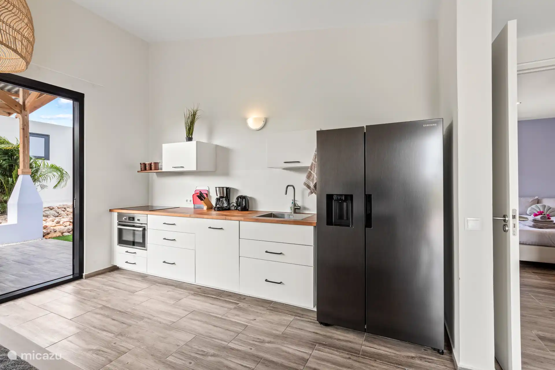 Voll ausgestattete Küche mit Induktionskochfeld, Kombibackofen, Geschirrspüler und amerikanischem Kühlschrank.