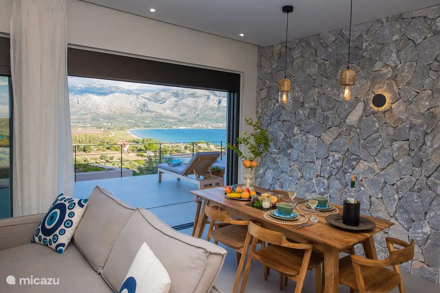 Table à manger à l'intérieur du salon avec vue sur la mer et les montagnes
