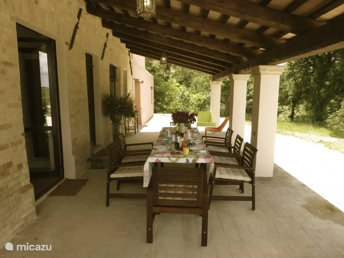 Der Portikus vor dem Haus mit Tischen und Stühlen