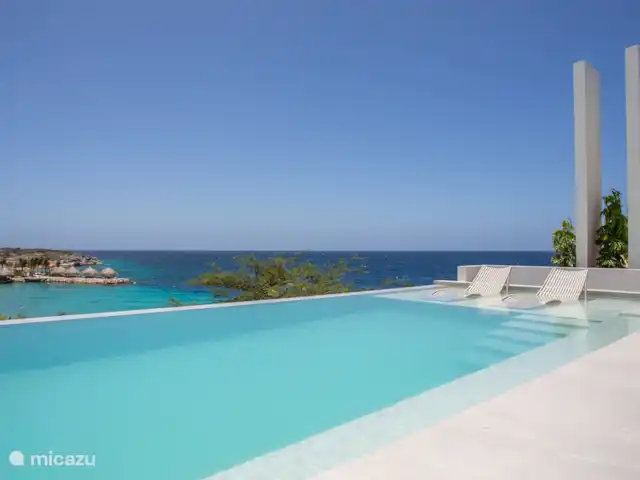 Station balnéaire de Blue Bay | Villa Bocazul 2 | Curaçao, Curaçao-Centre, Blue Bay - villa Piscine à débordement avec vue sur la baie de Blue Bay et la plage.