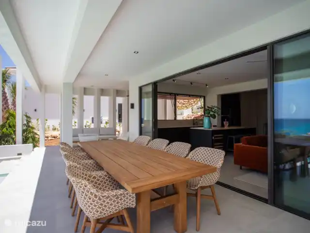 Station balnéaire de Blue Bay | Villa Bocazul 2 | Curaçao, Curaçao-Centre, Blue Bay - villa Spacieuse véranda ombragée avec entrée sur séjour et cuisine intérieure.