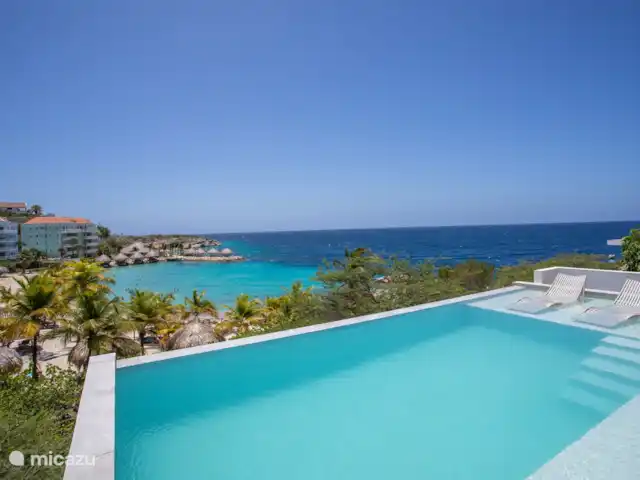 Station balnéaire de Blue Bay | Villa Bocazul 2 | Curaçao, Curaçao-Centre, Blue Bay - villa Piscine à débordement avec vue sur la baie de Blue Bay et la plage.
