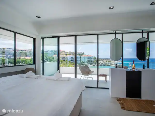 Station balnéaire de Blue Bay | Villa Bocazul 2 | Curaçao, Curaçao-Centre, Blue Bay - villa Chambre principale avec salle de bain privée et vue sur la baie de Blue Bay et la plage.