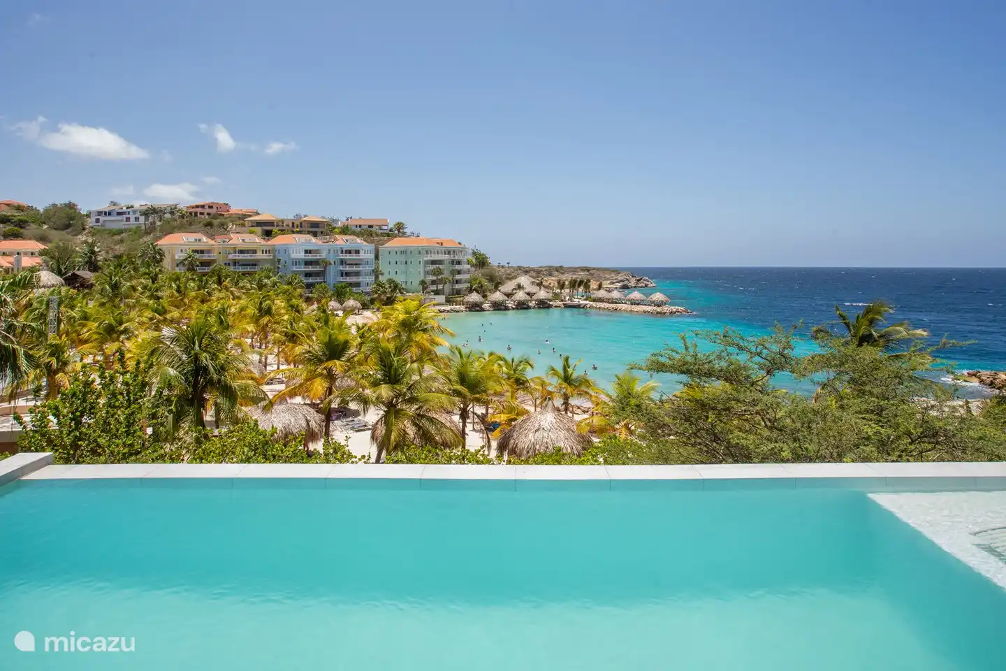 Piscine à débordement avec vue sur la baie de Blue Bay et la plage.