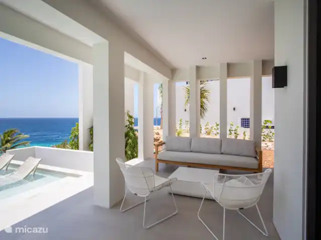 Station balnéaire de Blue Bay | Villa Bocazul 2 | Curaçao, Curaçao-Centre, Blue Bay - villa Spacieuse véranda ombragée avec coin salon, surplombant la baie de Blue Bay.