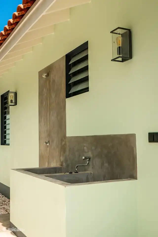 Derrière la maison il y a de la place pour rincer le matériel de plongée/snorkeling et une douche extérieure