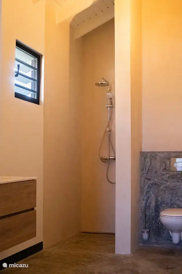 Salle de bain avec douche spacieuse, double vasque et toilettes