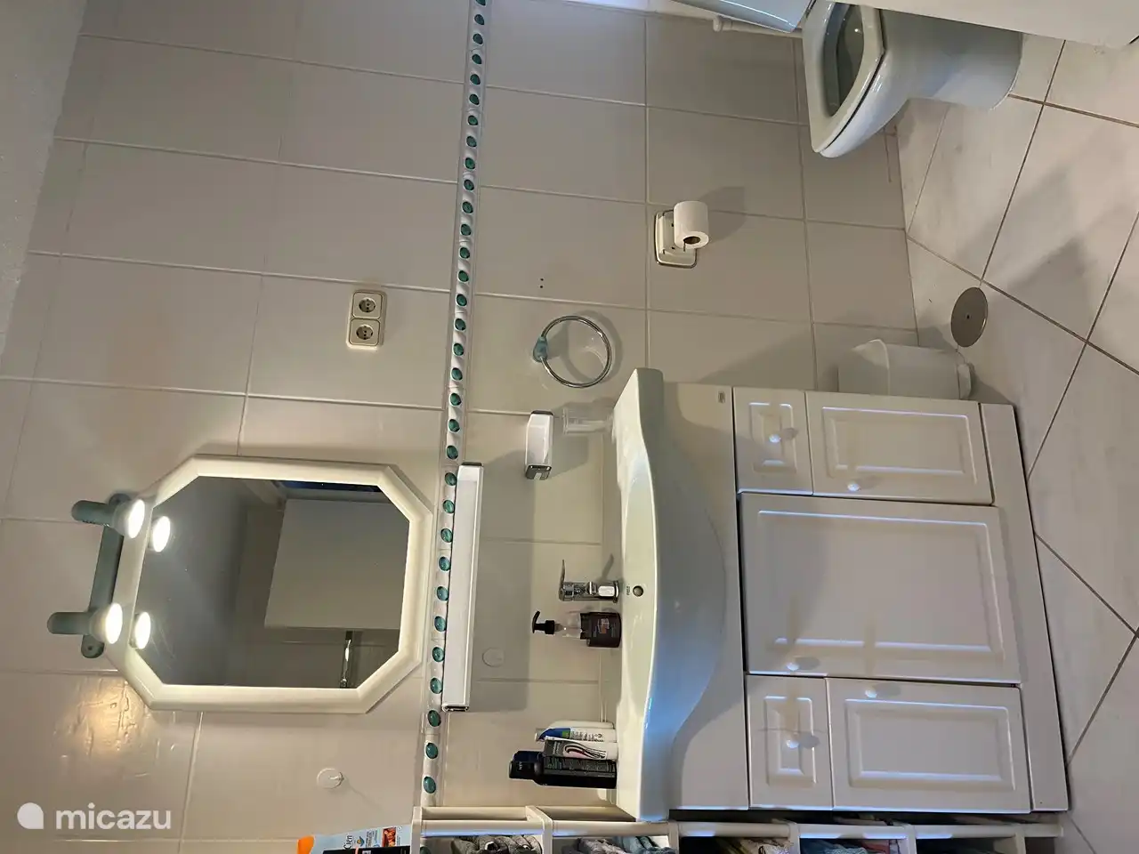 Badezimmer mit Waschbecken, Dusche, Toilette und Waschmaschine