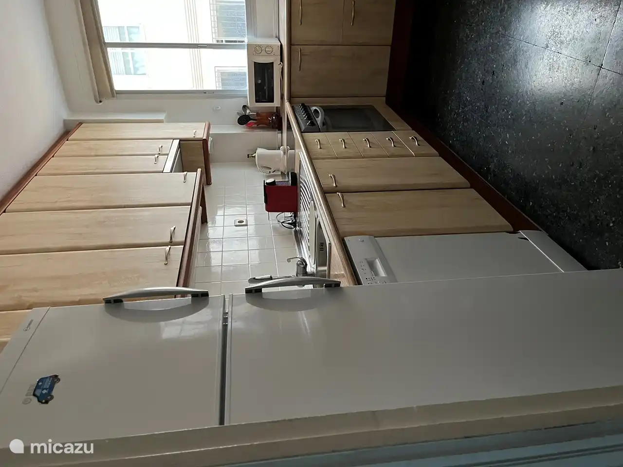 Küche mit Geschirrspüler, Backofen, Mikrowelle, Induktionskochfeld, Kühlschrank mit Gefrierfach 