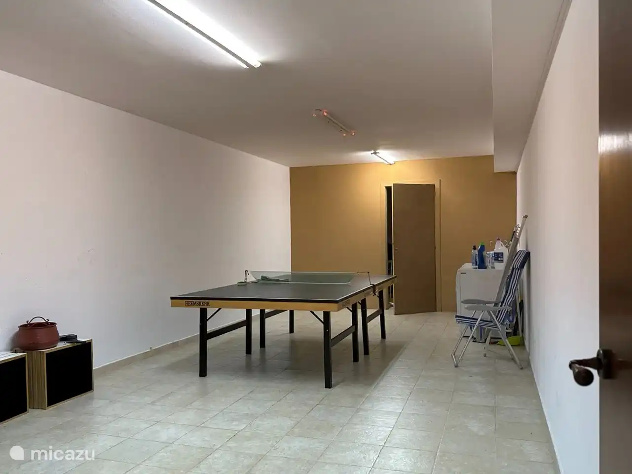 Pièce en bas avec lave-linge et sèche-linge et table de ping-pong
