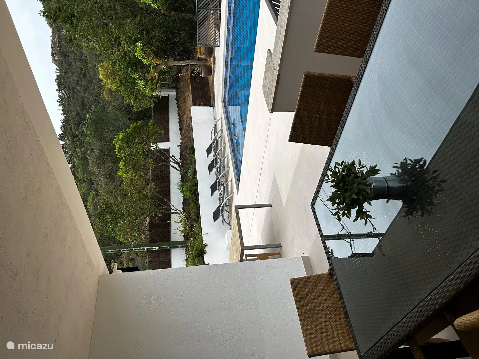 Terrasse couverte avec table à manger et sur la terrasse au bord de la piscine une autre grande table à manger 