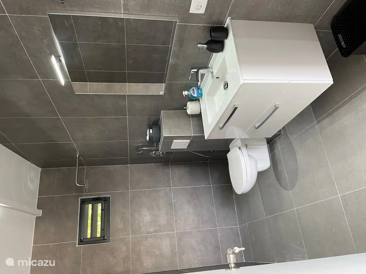 Een modern ingerichte badkamer met   warm water door middel van een zonneboiler.