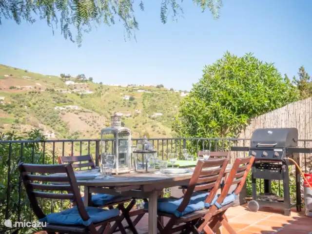 vakantiehuis huren in Spanje, Andalusië, Cómpeta – Finca Galliano Terras onder aan het huis met grote eetafel en BBQ. Uitzicht naar het noordwesten