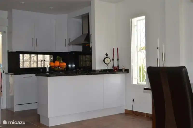 cocina abierta de color blanco brillante con encimera de mármol