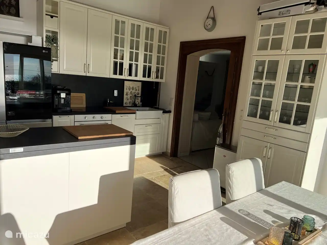 Küche mit Kühl- und Gefrierschrank, Spülmaschine, Backofen, Induktionskochfeld, Nespresso Kaffeemaschine, Toaster, Wasserkocher. Töpfe, Pfannen, Teller, Besteck.