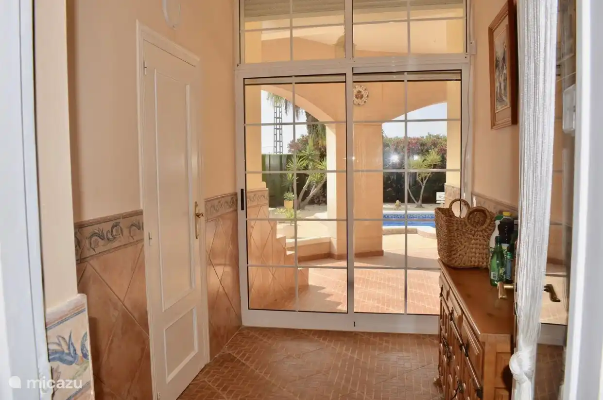 Flur von der Küche mit Durchgang zur Veranda und zum Schwimmbad. Zusätzliche Toilette und Waschküche mit Waschmaschine, Bügelbrett und allen Reinigungsmitteln sowie Dyson-Staubsauger