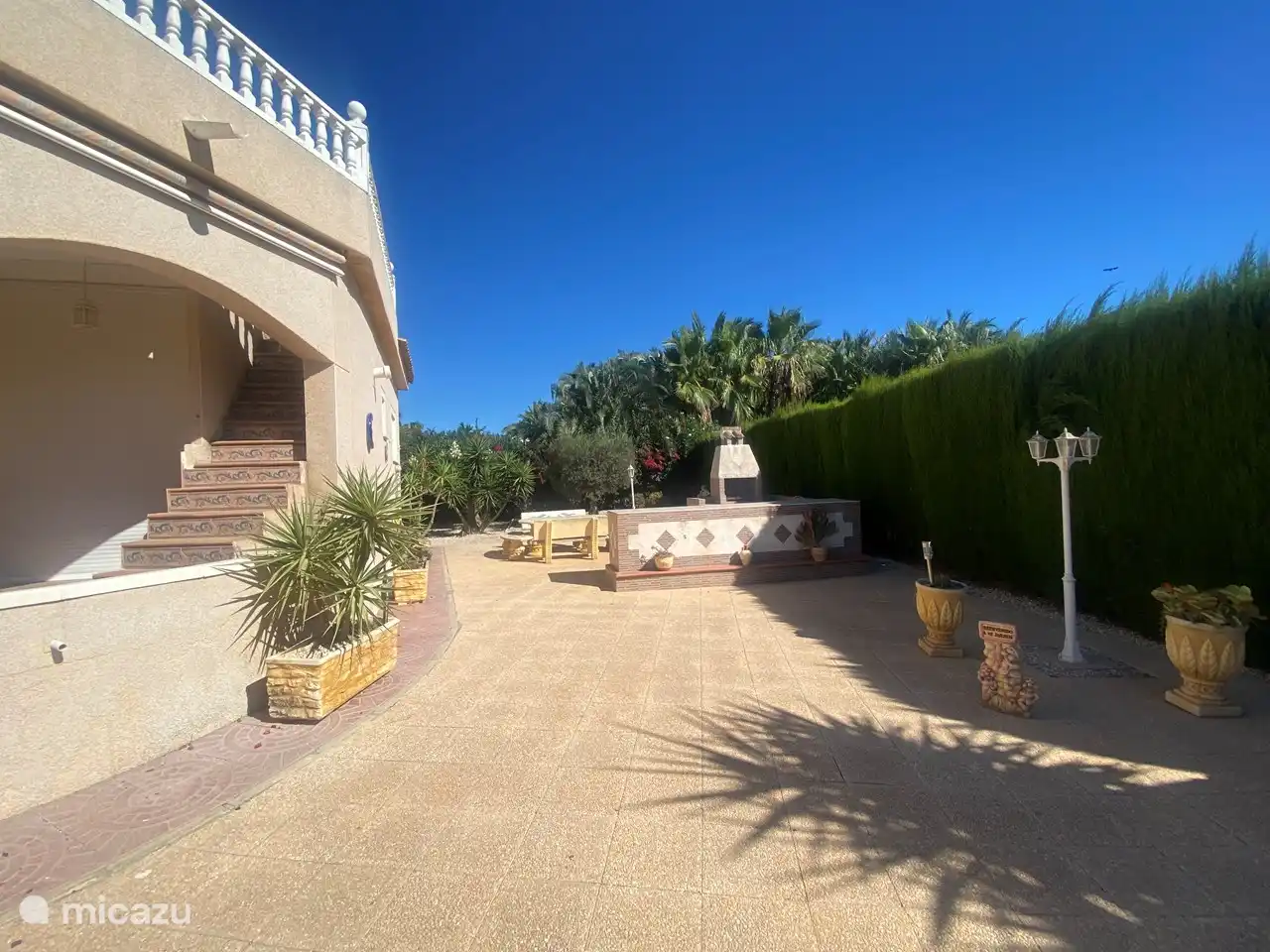 Die Außenküche mit Grill und Esstisch aus Stein