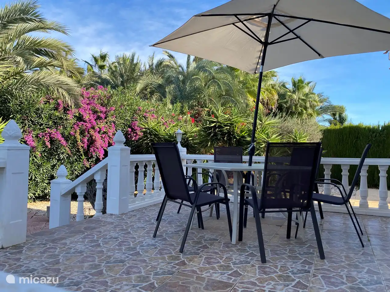 Unter dem Sonnenschirm auf der Veranda am Esstisch für 6 Personen.