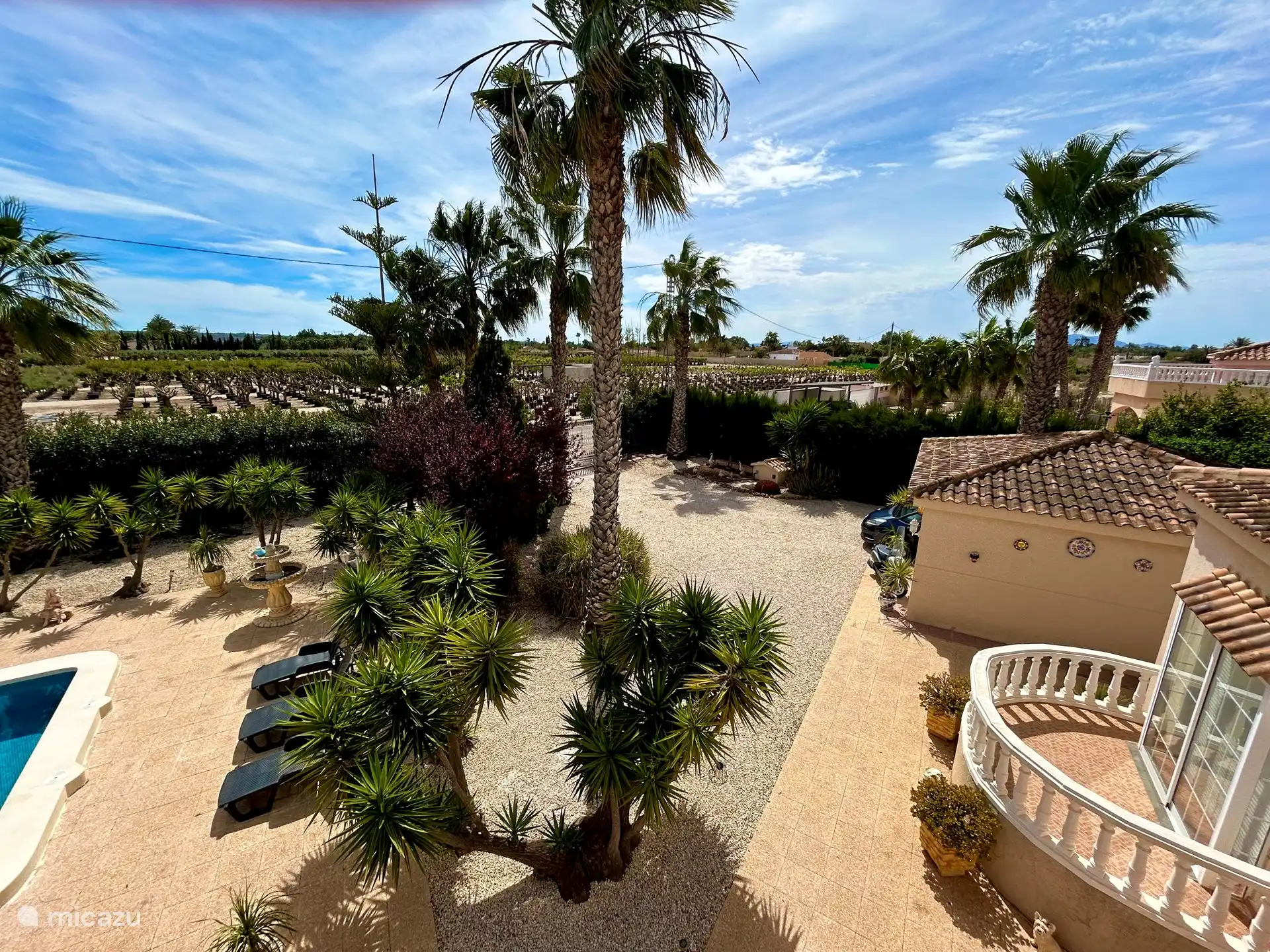 Blick auf den Garten vom Balkon. Der Garten bietet Platz für mehrere Autos, Wohnmobile und Wohnwagen können auch problemlos darauf stehen. Das elektrisch betriebene Schiebetor sorgt dafür, dass Ihre wertvollen Fahrzeuge gut gesichert sind. Kameraüberwachung und Alarm auf dem Parkplatz sind vorhanden. 