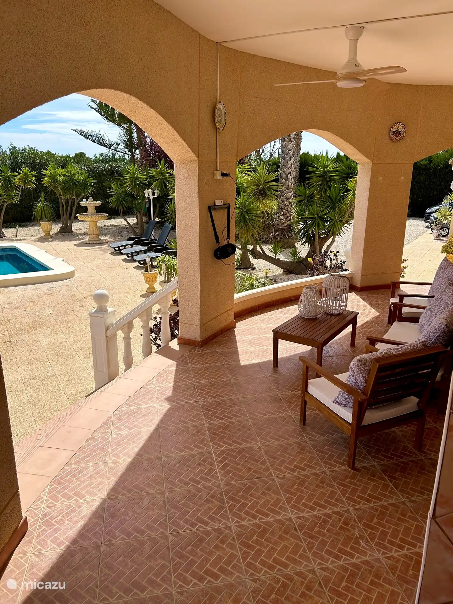 Überdachte Veranda mit Blick auf den Garten und den Pool 