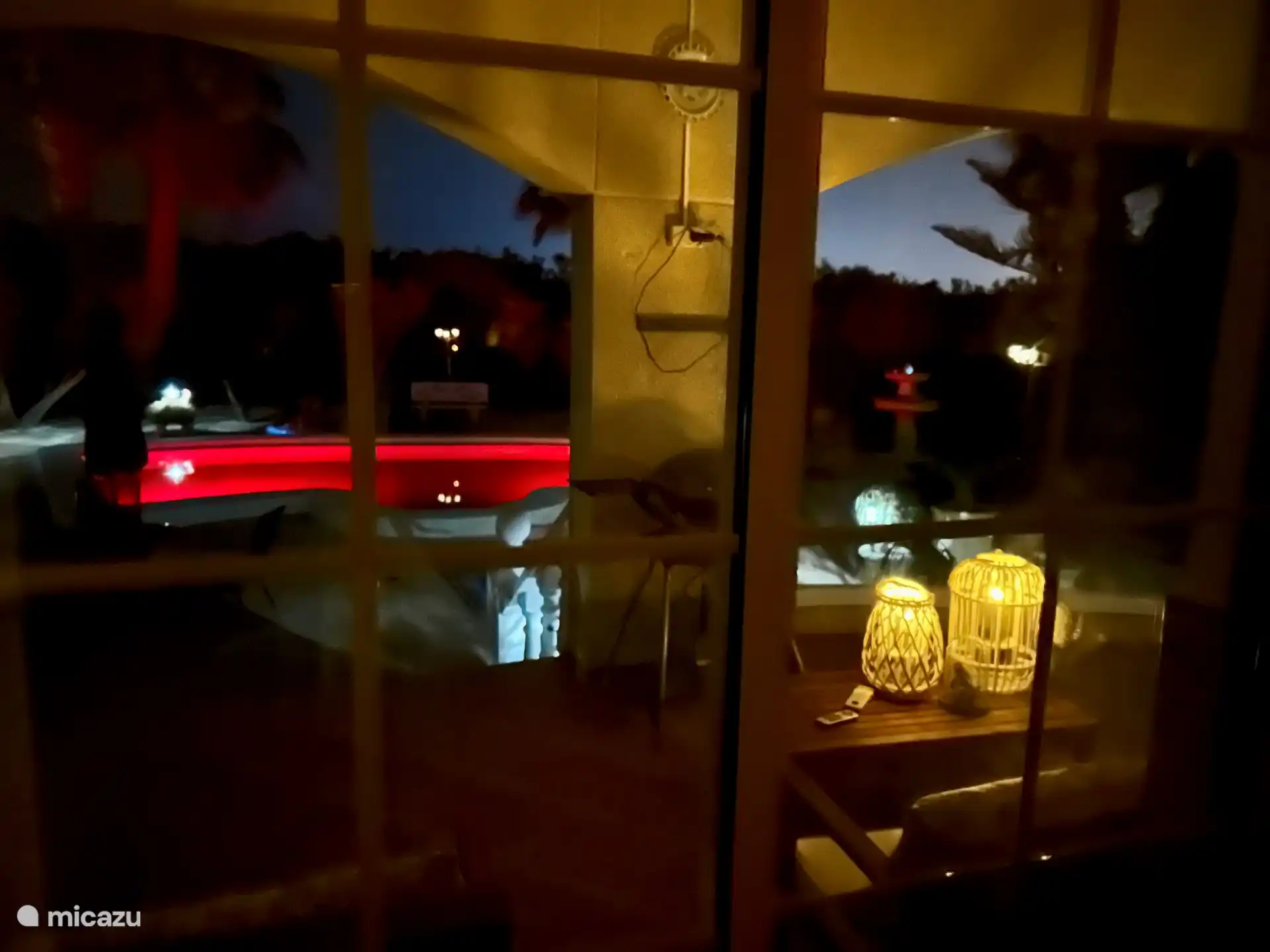 Blick auf den geschmackvoll eingerichteten Garten vom Wohnzimmer aus. Dank der vielen und hohen Fenster rund um das Wohnzimmer können Sie herrlich romantische Abende erleben. 