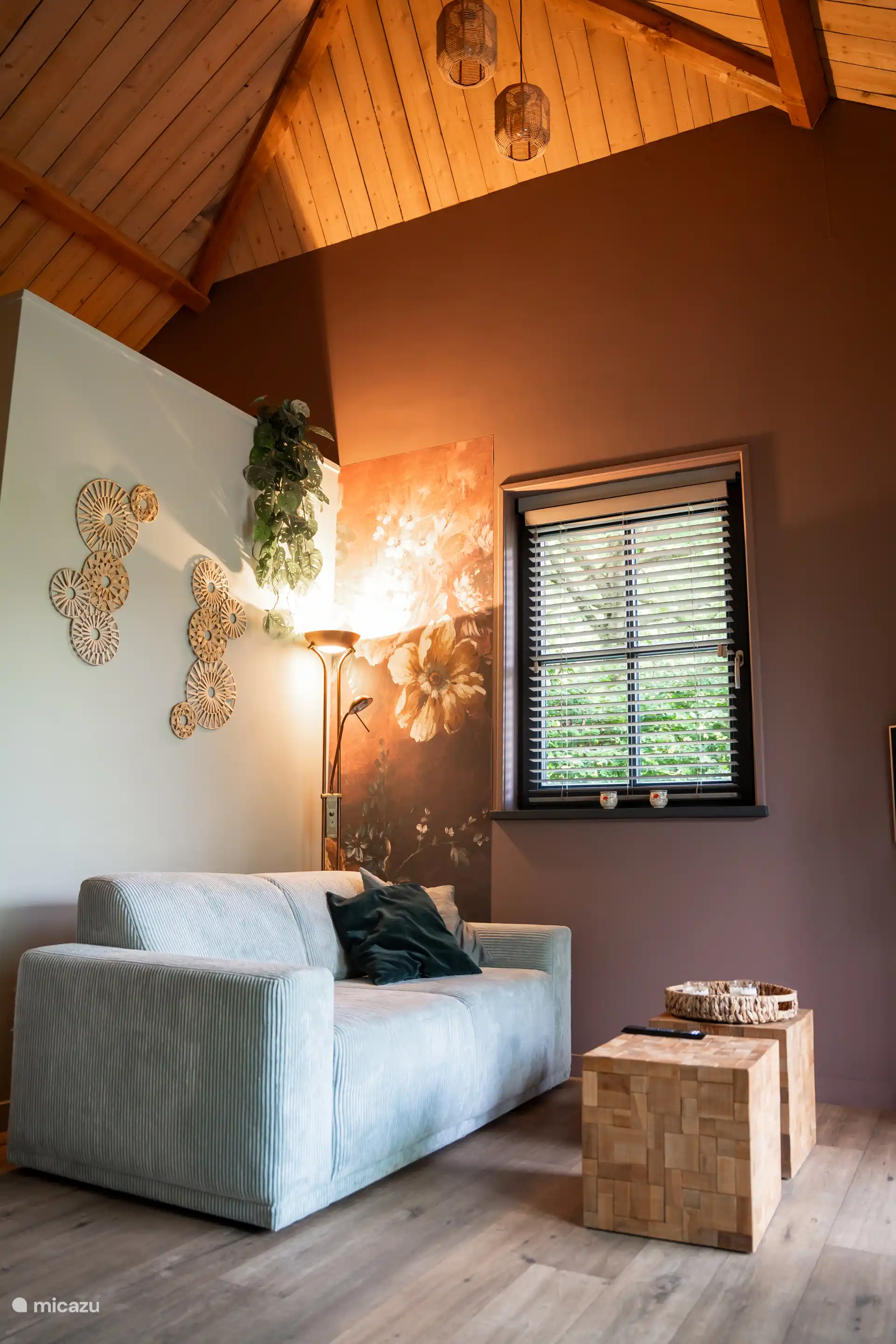 Un salón acogedor con smart TV y vistas a través de las grandes ventanas del jardín.