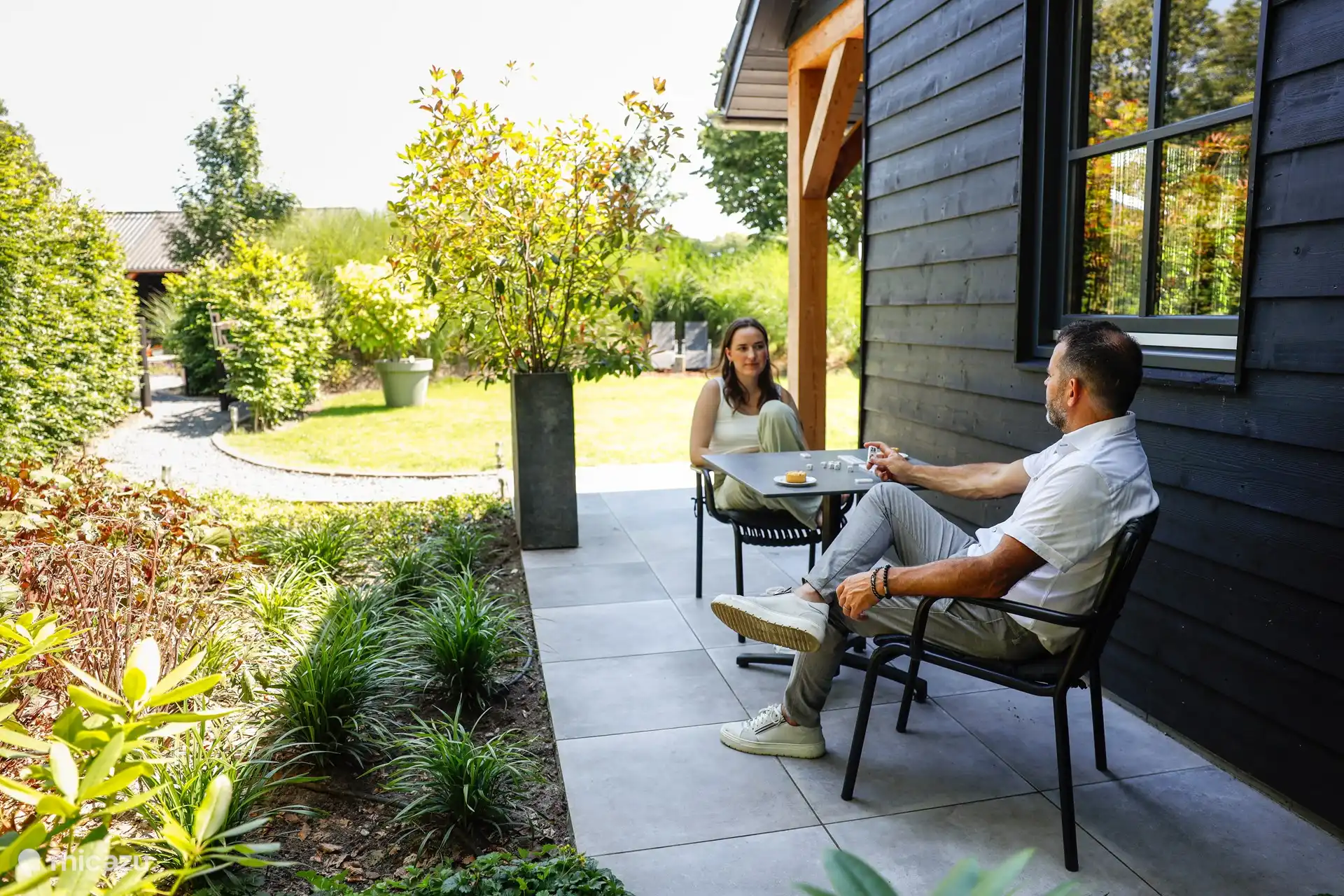 Großzügiger grüner Garten mit mehreren Sitzgelegenheiten. 