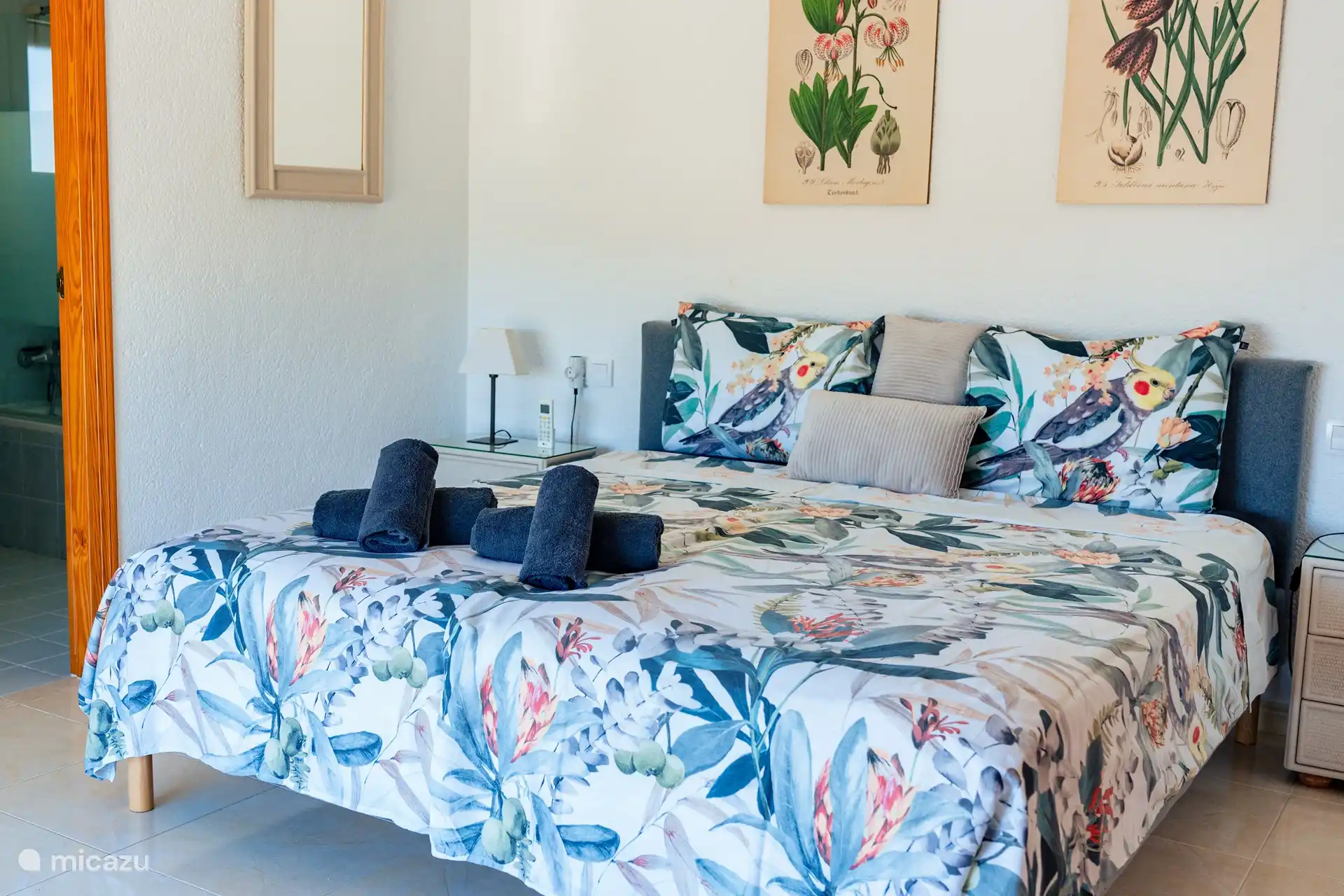 Hauptschlafzimmer mit schöner Aussicht, Schränken, Schreibtisch mit Stuhl, Badezimmer mit ebenerdiger Dusche, Waschbecken und WC, Klimaanlage und Ventilator