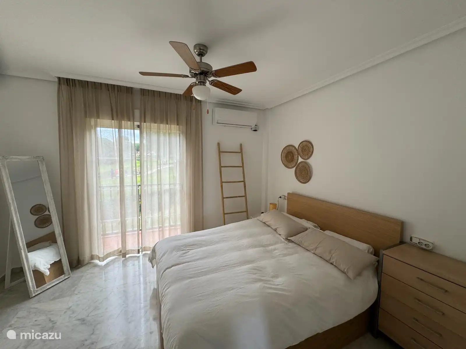 The master bedroom with double bed and built-in wardrobe. Equipped with renewed air conditioning, (separately adjustable) and ceiling fan. You have a view of the golf course from here. 
The bedroom is directly connected to the bathroom 