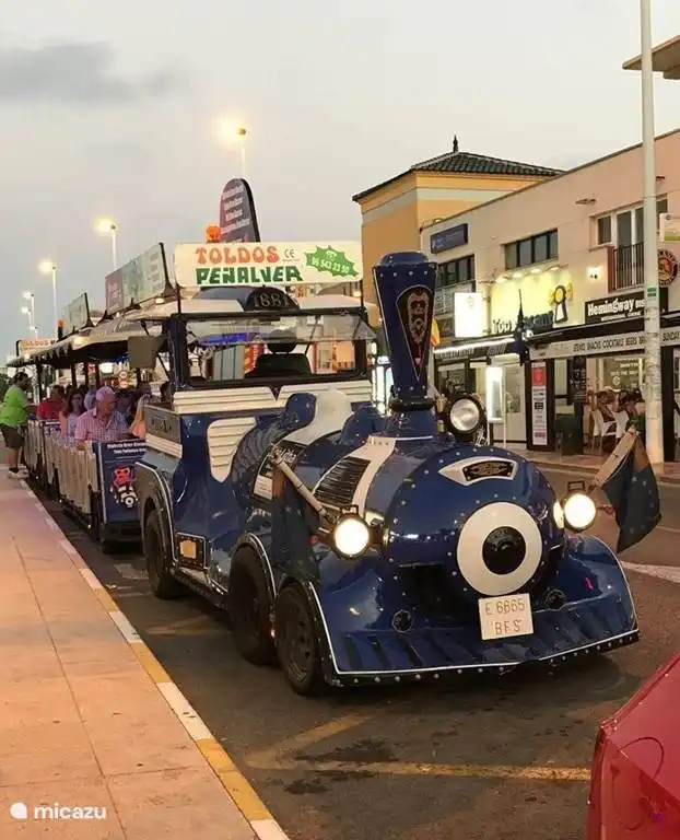 The tourist train stops near the urbanization.