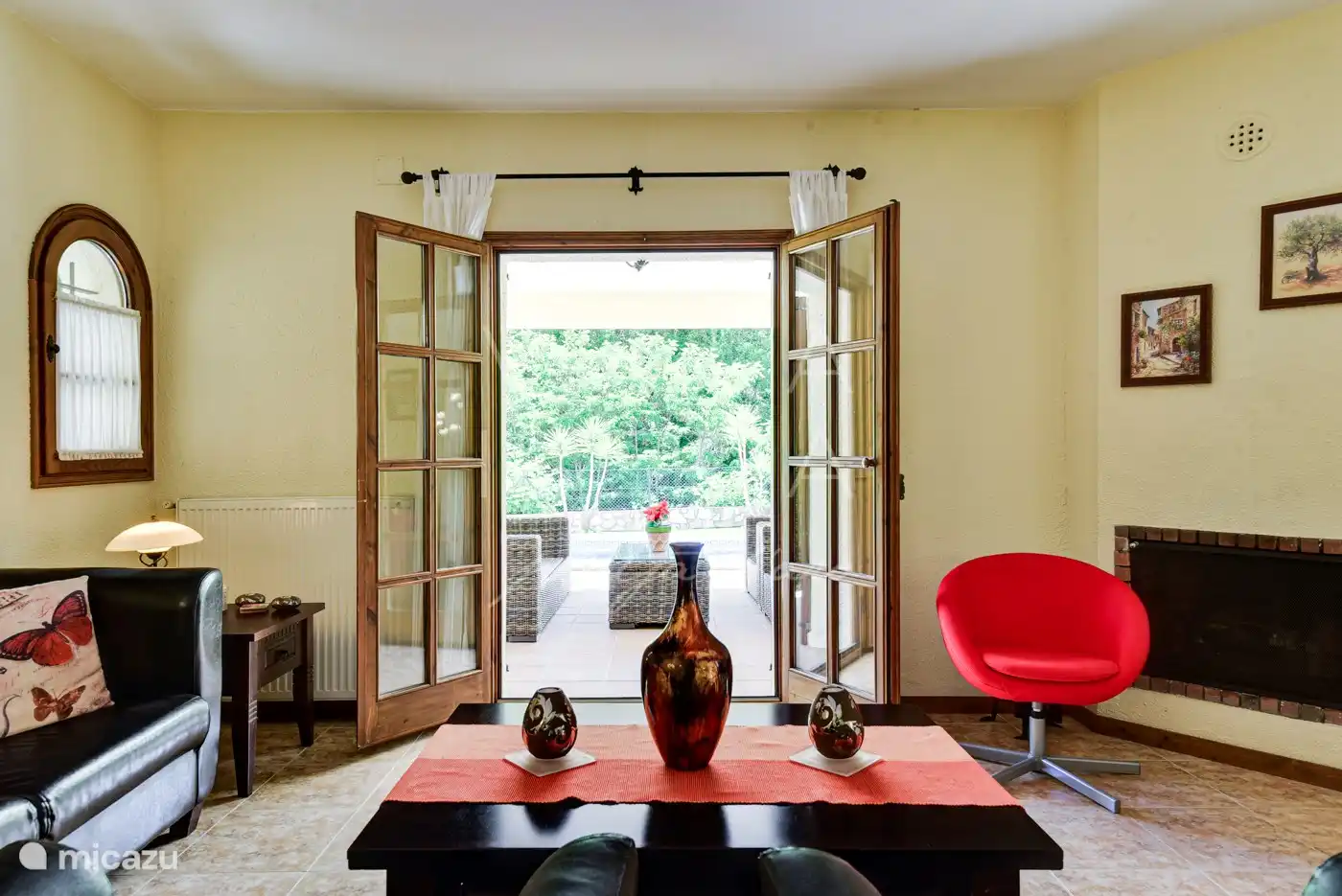 Coin salon dans le salon avec portes-fenêtres donnant sur la terrasse