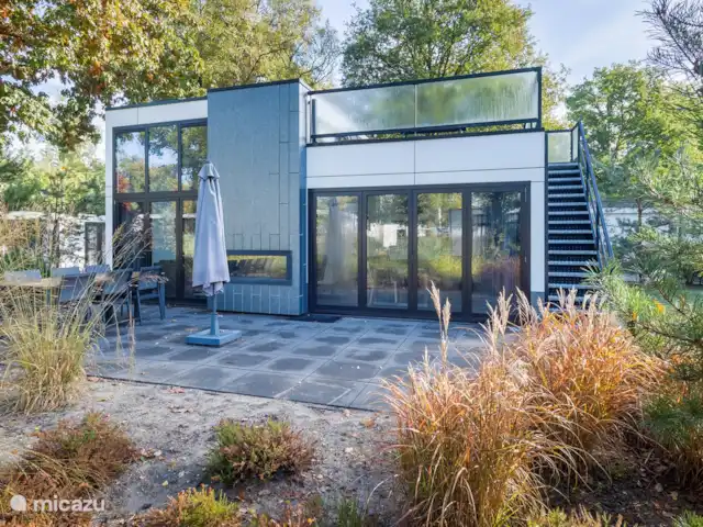 Maison de vacances Maridu Forest Cube | Pays-Bas, Gueldre, Arnhem - maison de vacances la vue extérieure et la terrasse avec foyer au gaz visible de l'intérieur et de l'extérieur