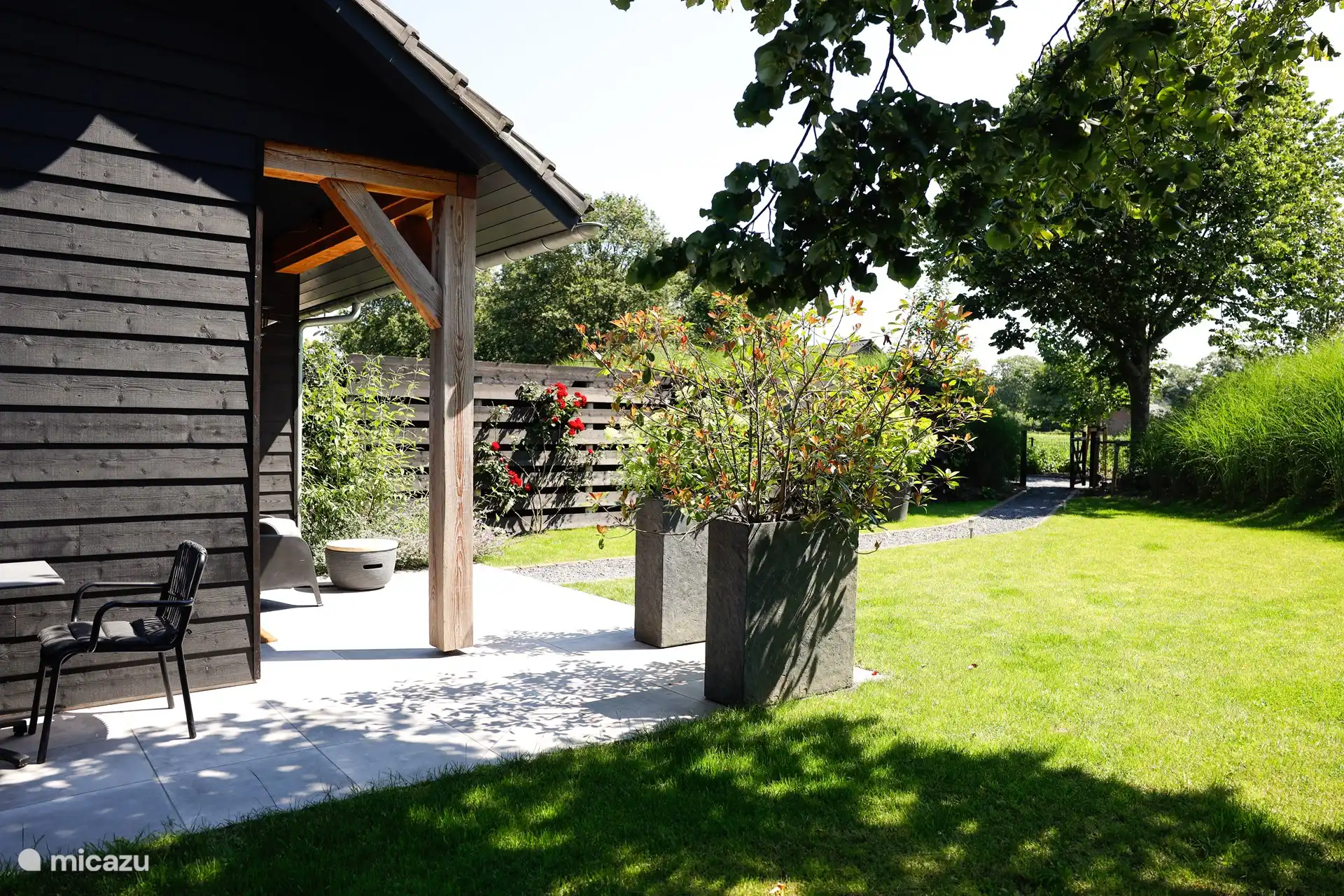 Großzügiger grüner Garten mit mehreren Sitzgelegenheiten.