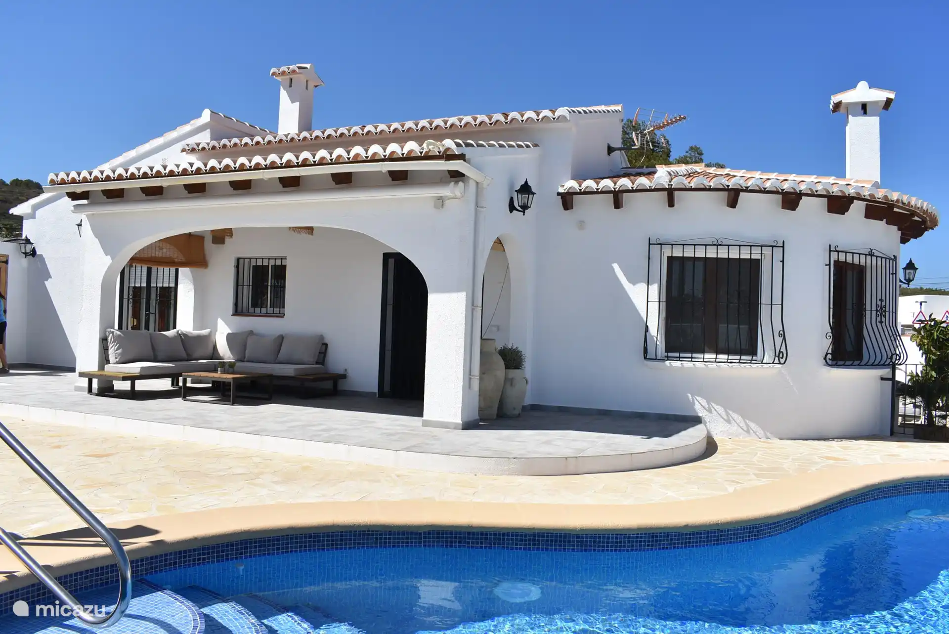 La mesa del comedor está al costado de la casa y el área del salón está al lado de la piscina. Esta foto es correcta.