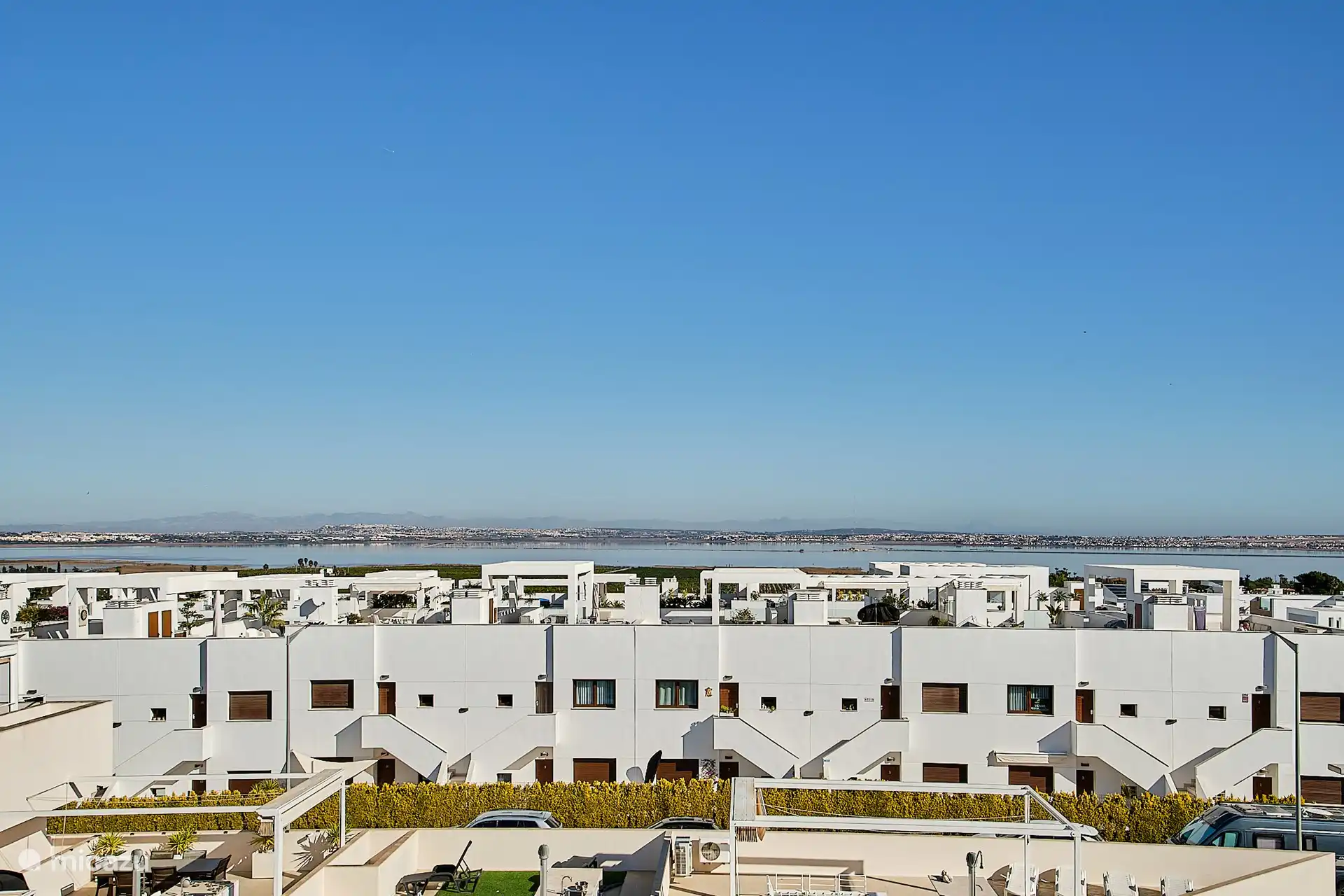 Vanaf het dakterras prachtig zicht op het roze meer, over de rij appartementen heen