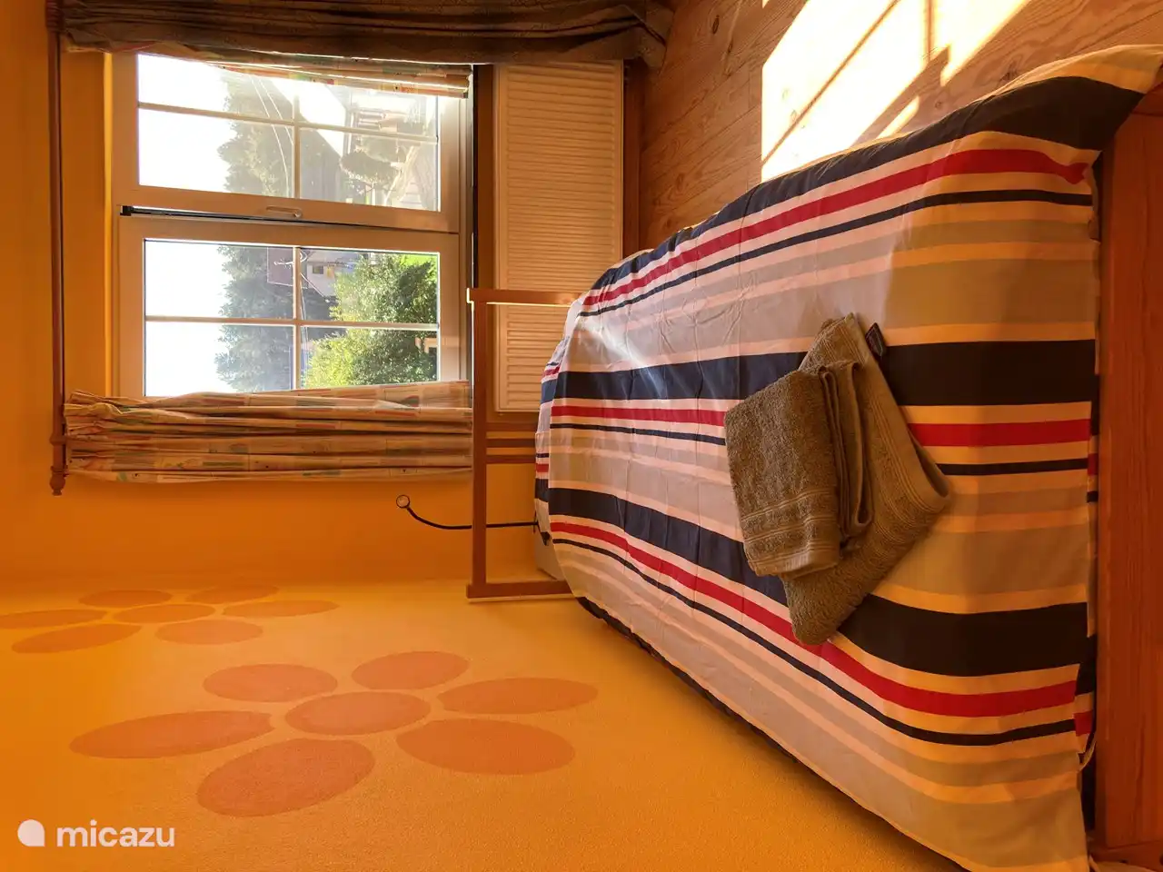 Kleiner kamer met een 1-persoonsbed, opbergkastje , tafeltje en stoel.