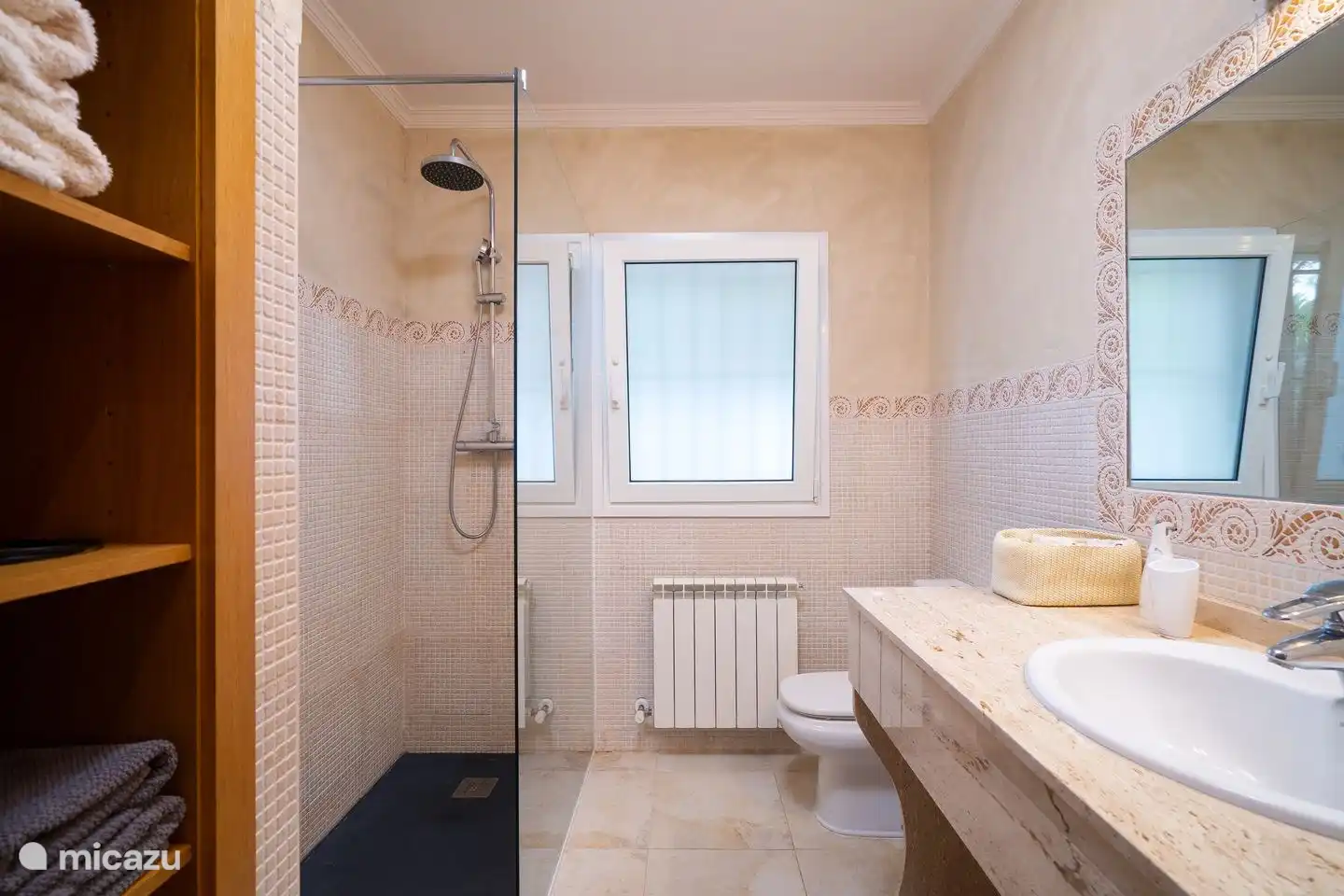 Geräumiges Badezimmer mit ebenerdiger Dusche, Toilette und Waschbecken im 1. Stock