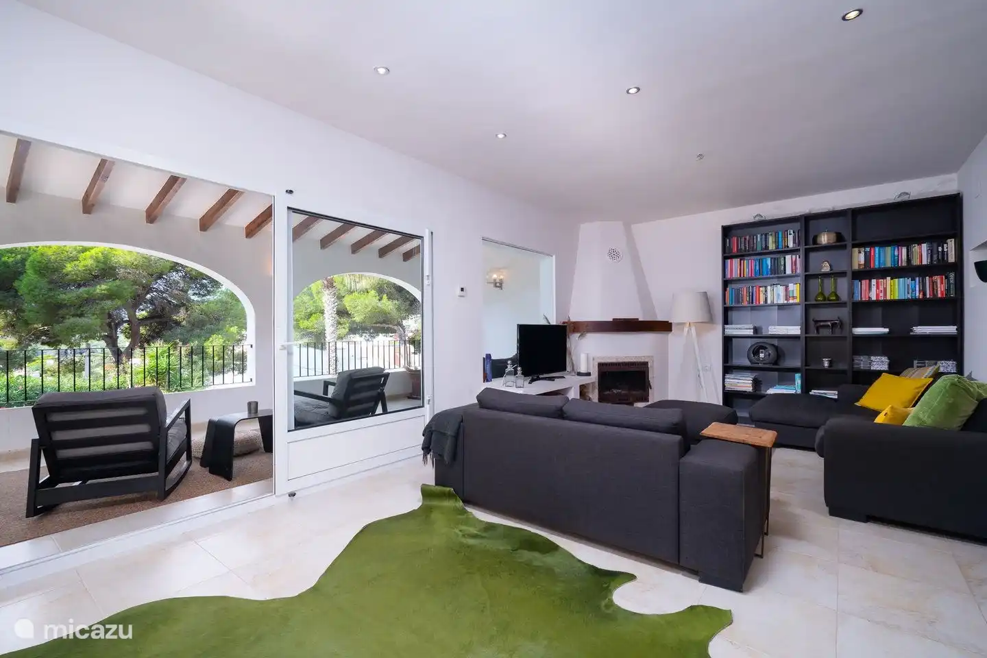 Wohnzimmer im 1. Stock, mit Schiebetüren mit Zugang zur überdachten Terrasse und Blick auf den Pool