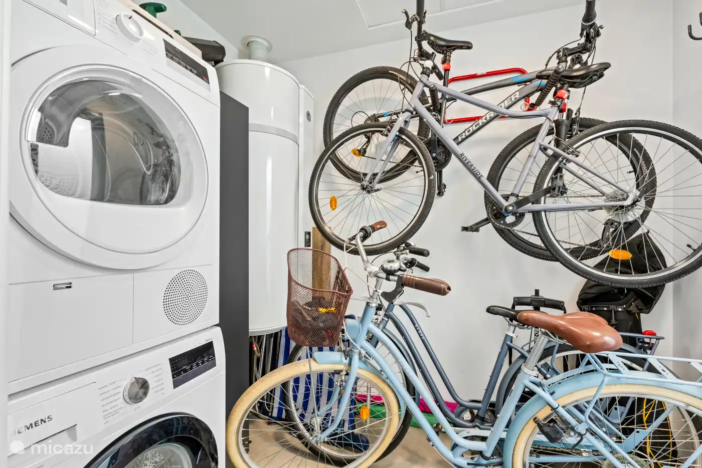 Abstellraum mit Waschmaschine und Trockner und 4 Fahrrädern.