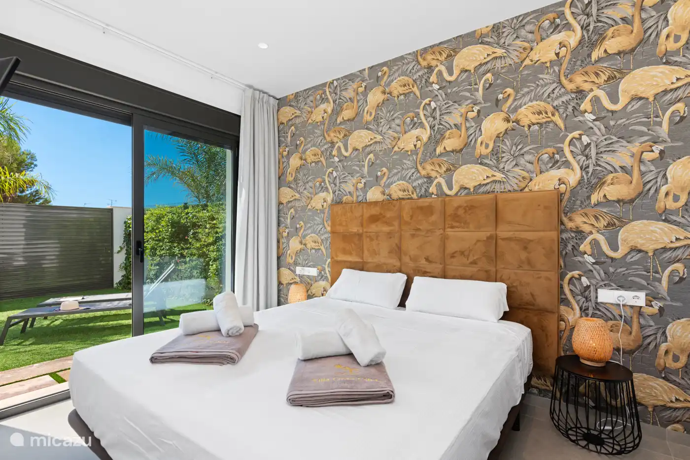 Schlafzimmer 1 mit 2 Einzelbetten, Klimaanlage, TV, eigenem Bad und Blick auf Pool/Garten